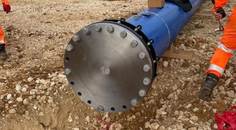 Wide view of a newly installed pipeline involving Nova Siria fittings and a blank flange at the end, shown on a construction site