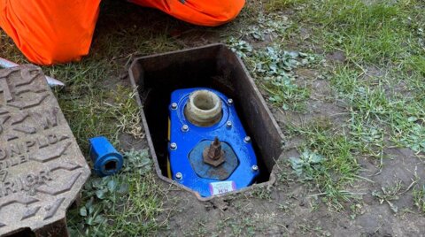 Engineer installing a Haldi hydrant safety clamp on a live, in-ground hydrant as part of on-site safety works