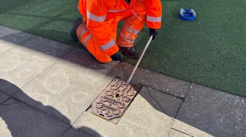 Engineer removing a hydrant cover prior to installing a Haldi hydrant safety clamp on a live hydrant