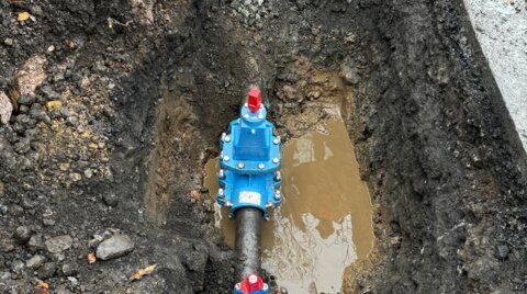 Overhead view of an excavation showing a newly installed EZ valve connected to a water main