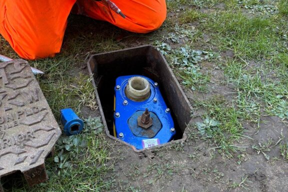 Engineer installing a Haldi hydrant safety clamp on a live, in-ground hydrant as part of on-site safety works