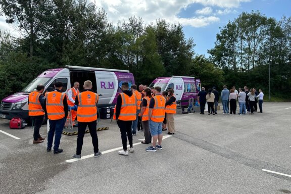 Multiple R2M roadshow vans set up on site, with technical experts engaging with customers to showcase pipeline products and solutions