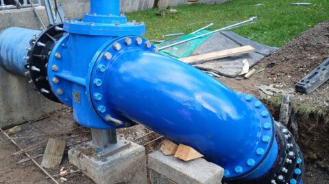 Installed emergency pipeline assembly showing end-restraint couplings, flange adaptors and a 90-degree bend, forming a secure flanged connection during urgent water network repairs