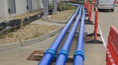 On-site System 2000 installation, showing three parallel pipelines connected by couplings as part of an above-ground water network