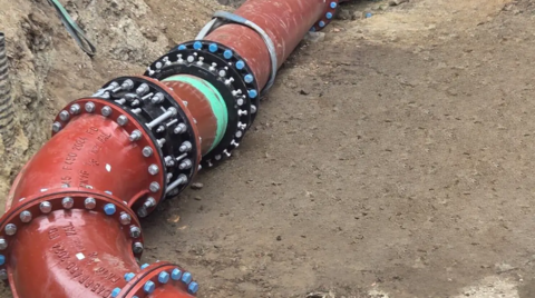 Bespoke ductile iron pipeline including flanged fittings and couplings installed in an excavated trench as part of a custom engineered solution