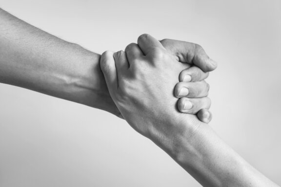 Hawle stands for reliability Two hands grip each other firmly as a symbol of reliability