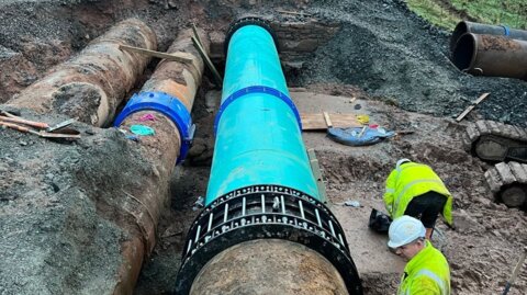 Installation of a Nova Siria Multigrip end restraint coupling on a large-diameter main within an excavated trench