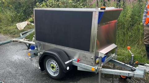 Side view of the trailer-mounted unit, positioned on a wet road surface