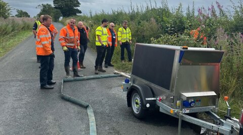 Engineers observing the trailer-mounted unit during live operation
