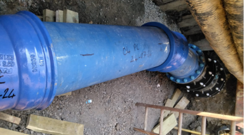 Blue PE pipe installed within the trench, connected to the existing main using a Nova Siria NovaGrip flange adaptor