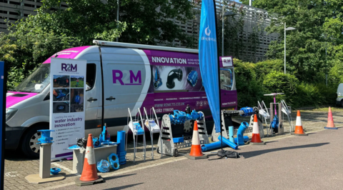 R2M Roadshow display featuring a branded van with pipeline products and fittings showcased outdoors